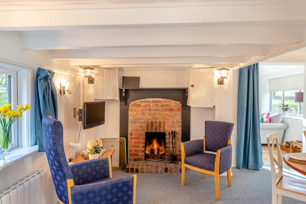Seating area by an open fire in a holiday cottage